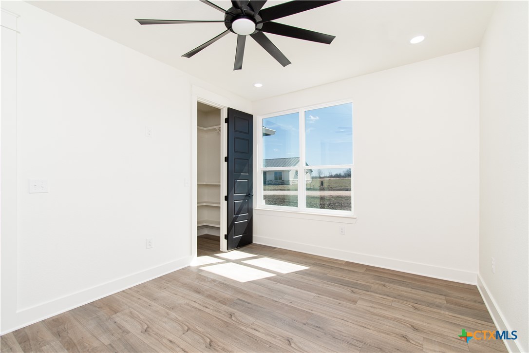 4245 Stringtown Road Temple, TX 76501 - Photo 22 of 25 an empty room with wooden floor closet and fan