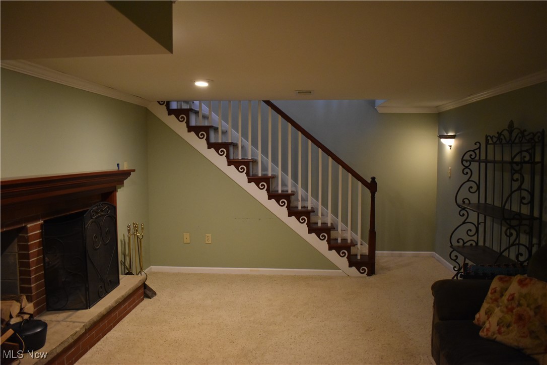 525 Harding Road Zanesville, OH 43701 - Photo 17 of 22 Stairway with crown molding, a fireplace, and carpet floors