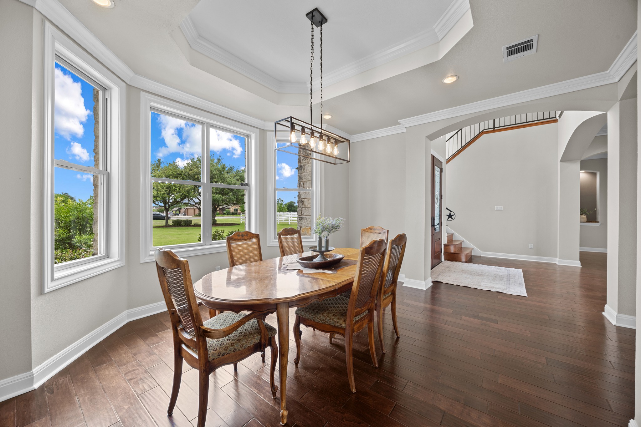 341 Courtnee's Way Georgetown, TX 78626 - Photo 5 of 40 The formal dining room has a deep tray ceiling and elegant crown molding that frame the space, while a bay of oversized windows floods the room with natural light.