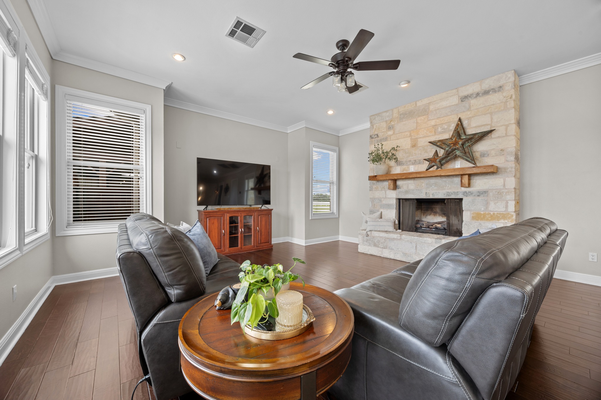 341 Courtnee's Way Georgetown, TX 78626 - Photo 9 of 40 The open-concept family room features a stunning floor-to-ceiling stone fireplace with a rustic wood mantel—perfect for those chilly Texas evenings.