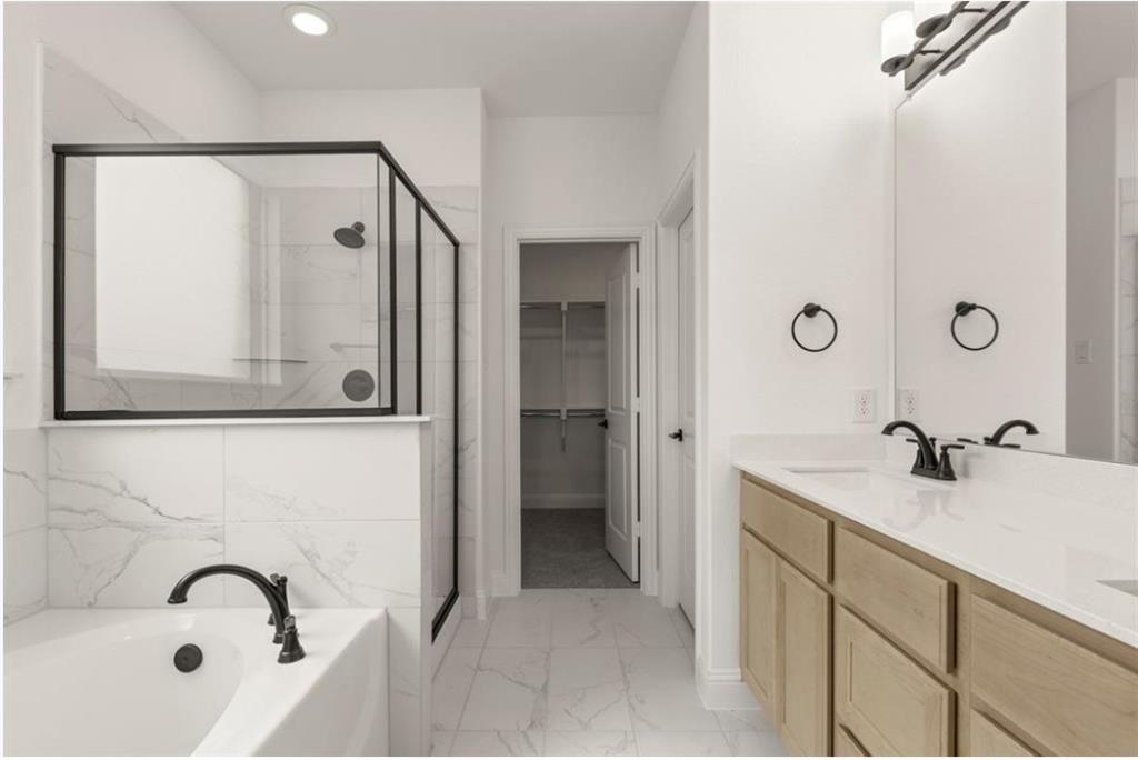 2902 Hanscom Street Forney, TX 75126 - Photo 13 of 28 Bathroom featuring a stall shower, light marble finish floors, a bath, double vanity, and a walk in closet