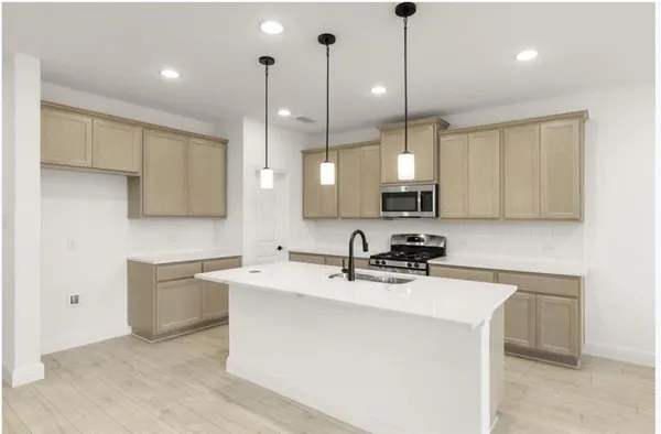 a kitchen with a sink a counter space appliances and cabinets