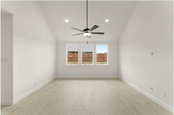 an empty room with a ceiling fan and window
