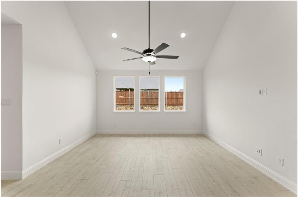 2902 Hanscom Street Forney, TX 75126 - Photo 8 of 28 Empty room with light wood finished floors, ceiling fan, and vaulted ceiling