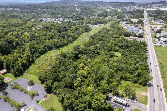 an aerial view of residential houses with outdoor space and trees