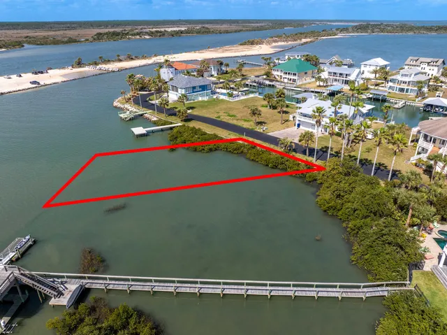 an aerial view of a residential houses with outdoor space and ocean view