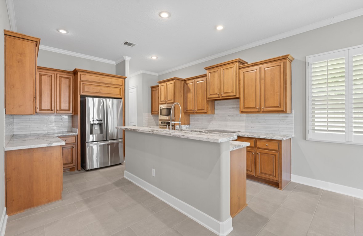 11206 Castille Lane Houston, TX 77082 - Photo 29 of 45 a kitchen with stainless steel appliances granite countertop a refrigerator and wooden cabinets