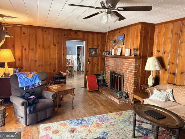 a living room with furniture a ceiling fan and a window