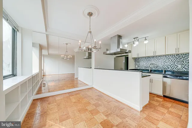 a view of a kitchen with a sink a counter top space stainless steel appliances and cabinets