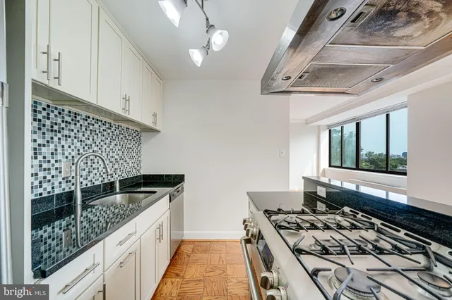 a kitchen with stainless steel appliances granite countertop a stove and a sink