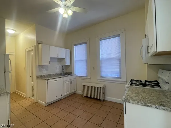 a kitchen with a sink a stove cabinets and a window