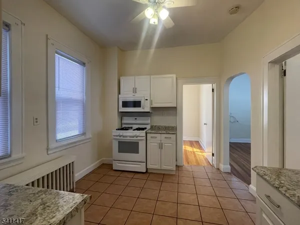 a kitchen with granite countertop a stove cabinets and refrigerator