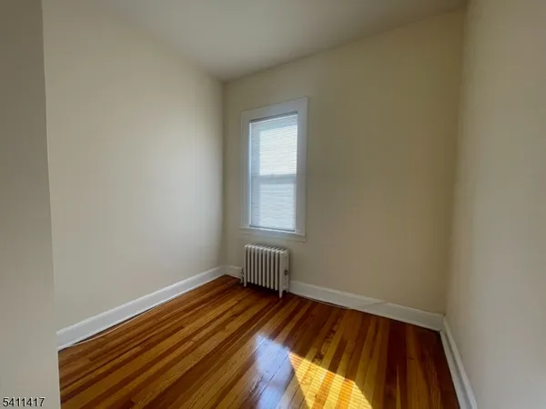 a view of a room with wooden floor and window