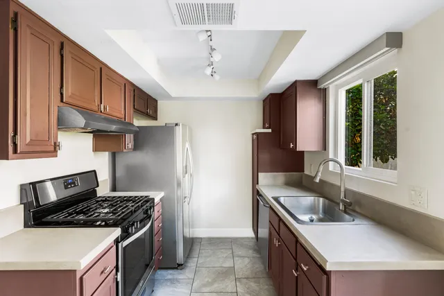 a kitchen with stainless steel appliances granite countertop a sink stove and refrigerator