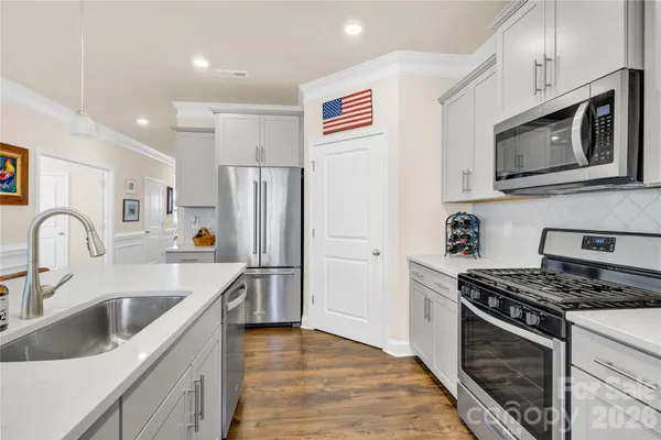 a kitchen with stainless steel appliances granite countertop a sink stove and refrigerator