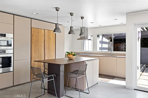 a kitchen with stainless steel appliances a table chairs and a refrigerator