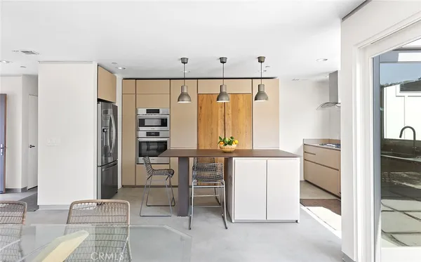 a kitchen with stainless steel appliances kitchen island granite countertop a refrigerator and cabinets