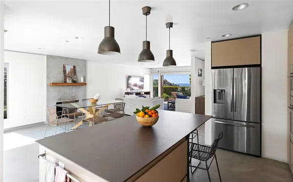 a kitchen with stainless steel appliances granite countertop a refrigerator a sink a stove and a dining table with the view