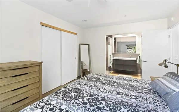 a view of a bedroom with wooden floor & bathroom