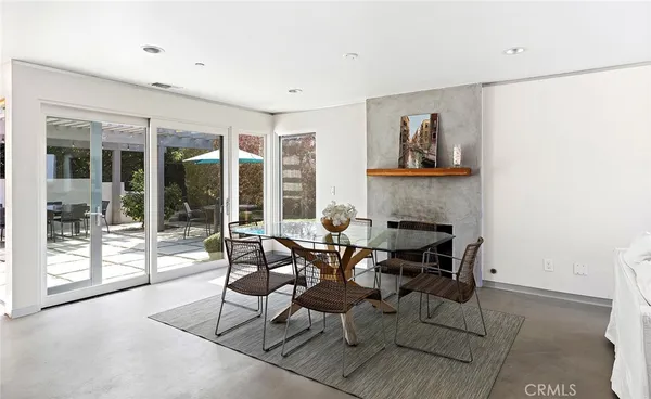 a dining room with furniture and large windows