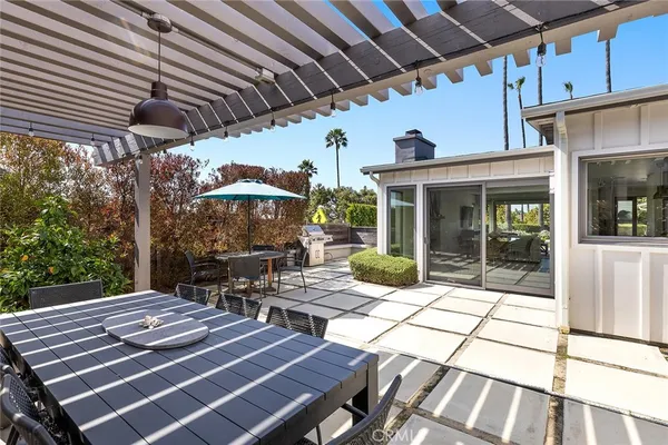 a view of a patio with table and chairs with wooden floor and fence