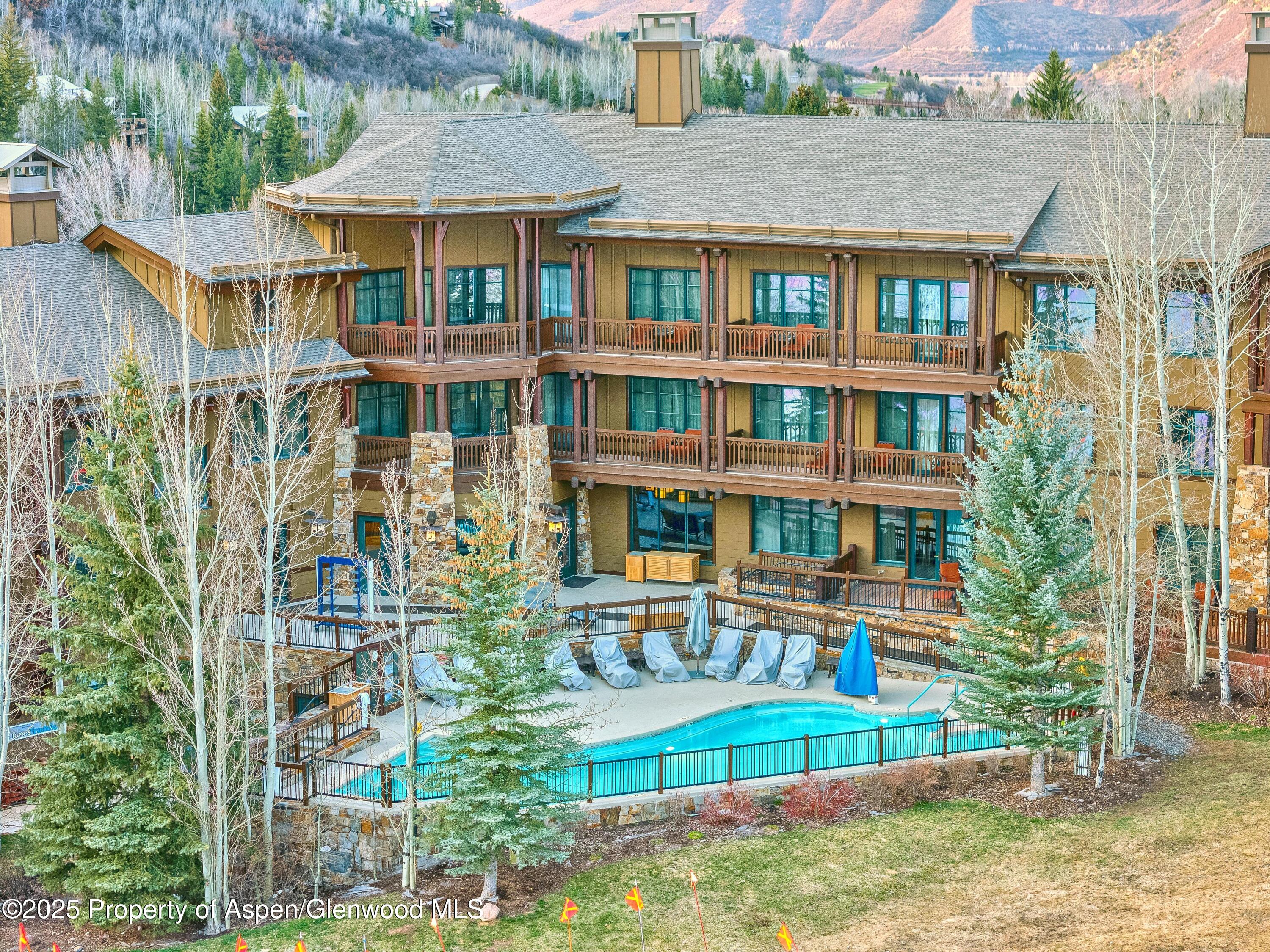 197 Prospector Road, Unit 2307SUMMER 12 Aspen, CO 81611 - Photo 16 of 18 a front view of a residential apartment building with a yard