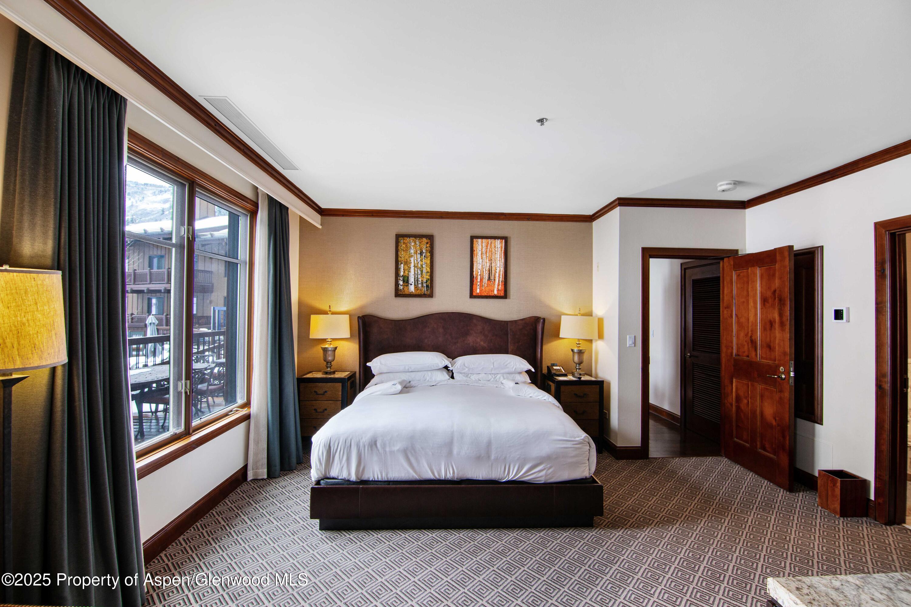 197 Prospector Road, Unit 2307SUMMER 12 Aspen, CO 81611 - Photo 3 of 18 a bedroom with a large bed and a window