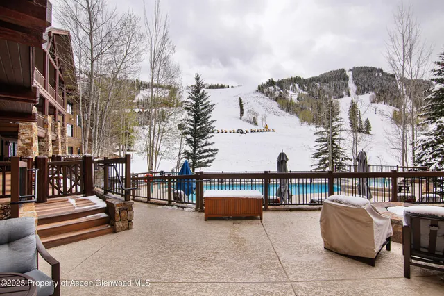 a view of a terrace with couches and wooden fence