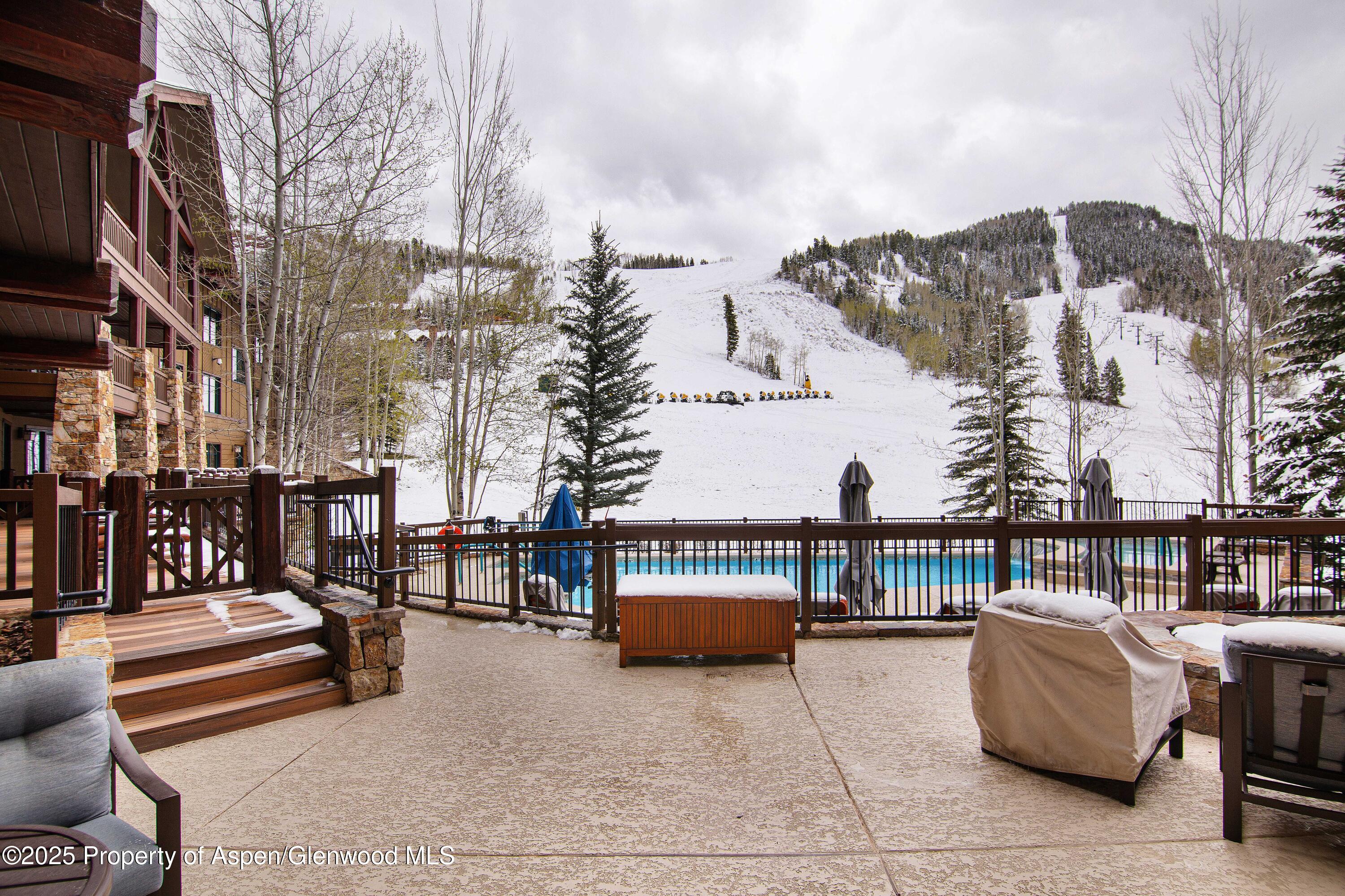 197 Prospector Road, Unit 2307SUMMER 12 Aspen, CO 81611 - Photo 5 of 18 a view of a terrace with couches and wooden fence