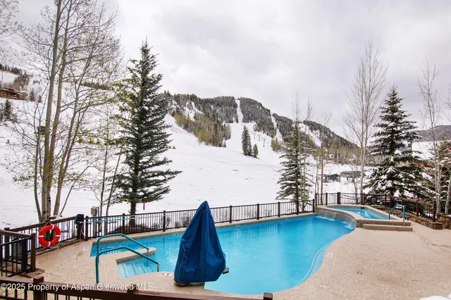 a view of pool with lawn chairs and iron fence