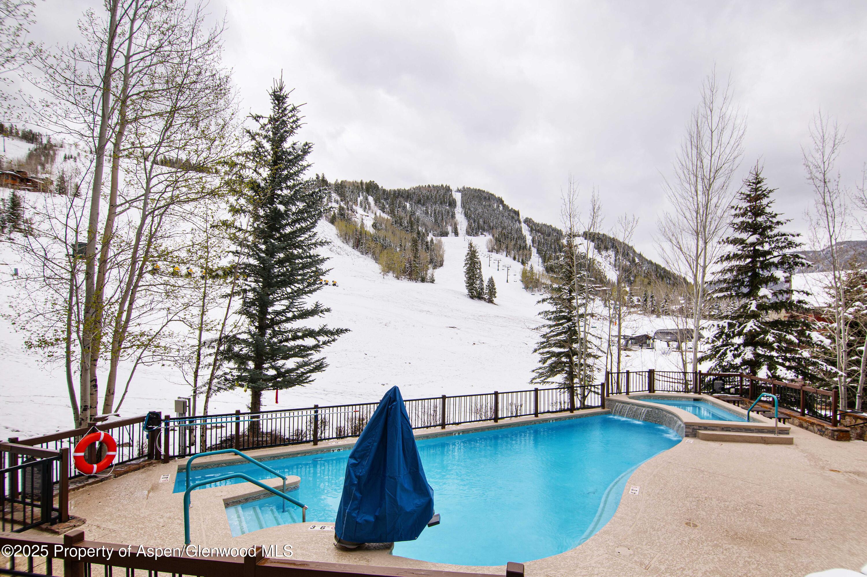 197 Prospector Road, Unit 2307SUMMER 12 Aspen, CO 81611 - Photo 7 of 18 a view of pool with lawn chairs and iron fence