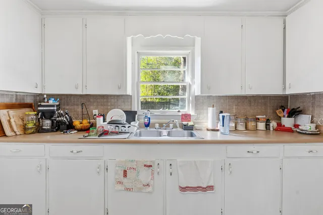 a kitchen with stainless steel appliances a sink a window and cabinets