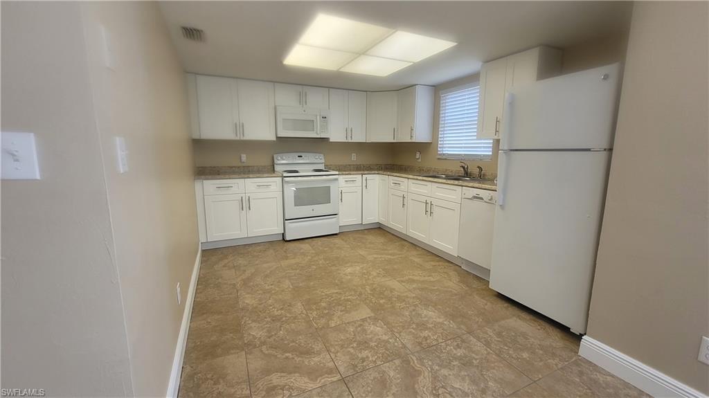 7504-7508 Pebble Beach Road Fort Myers, FL 33967 - Photo 1 of 13 a kitchen with cabinets and white appliances