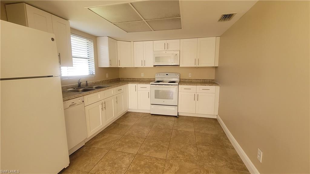 7504-7508 Pebble Beach Road Fort Myers, FL 33967 - Photo 2 of 13 a kitchen with a stove a sink and a refrigerator