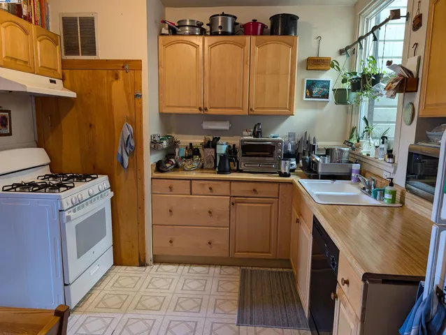 a kitchen with stainless steel appliances granite countertop a stove a sink and a refrigerator
