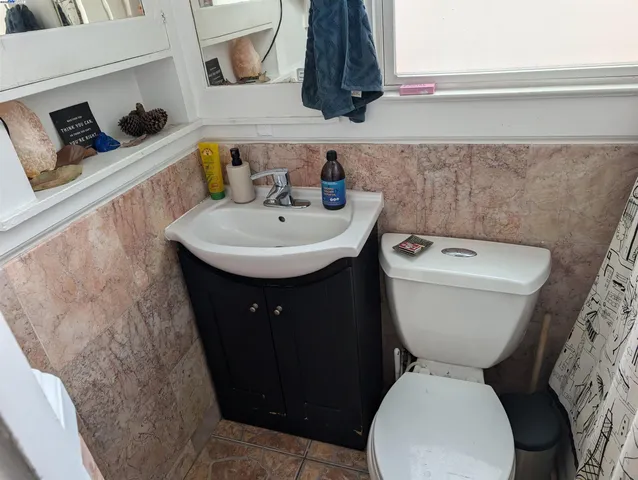 a bathroom with a toilet sink and mirror