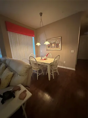 a dining room with furniture and wooden floor