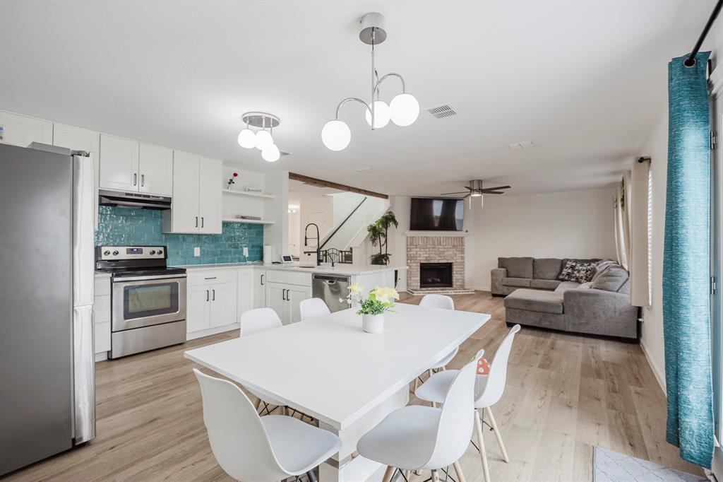 7935 Faithful Trail Dallas, TX 75237 - Photo 16 of 38 a kitchen with white cabinets and stainless steel appliances