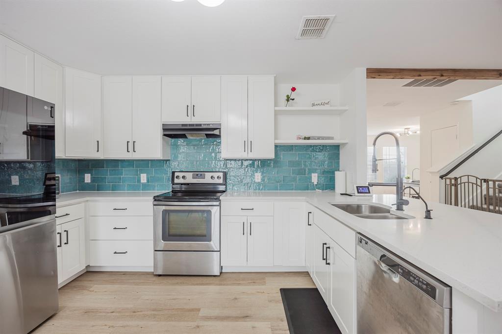 7935 Faithful Trail Dallas, TX 75237 - Photo 17 of 38 Kitchen featuring white cabinets, appliances with stainless steel finishes, open shelves, a peninsula, and light wood-style floors
