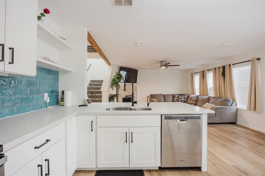 7935 Faithful Trail Dallas, TX 75237 - Photo 38 of 38 Kitchen featuring open shelves, stainless steel dishwasher, open floor plan, white cabinets, and decorative backsplash