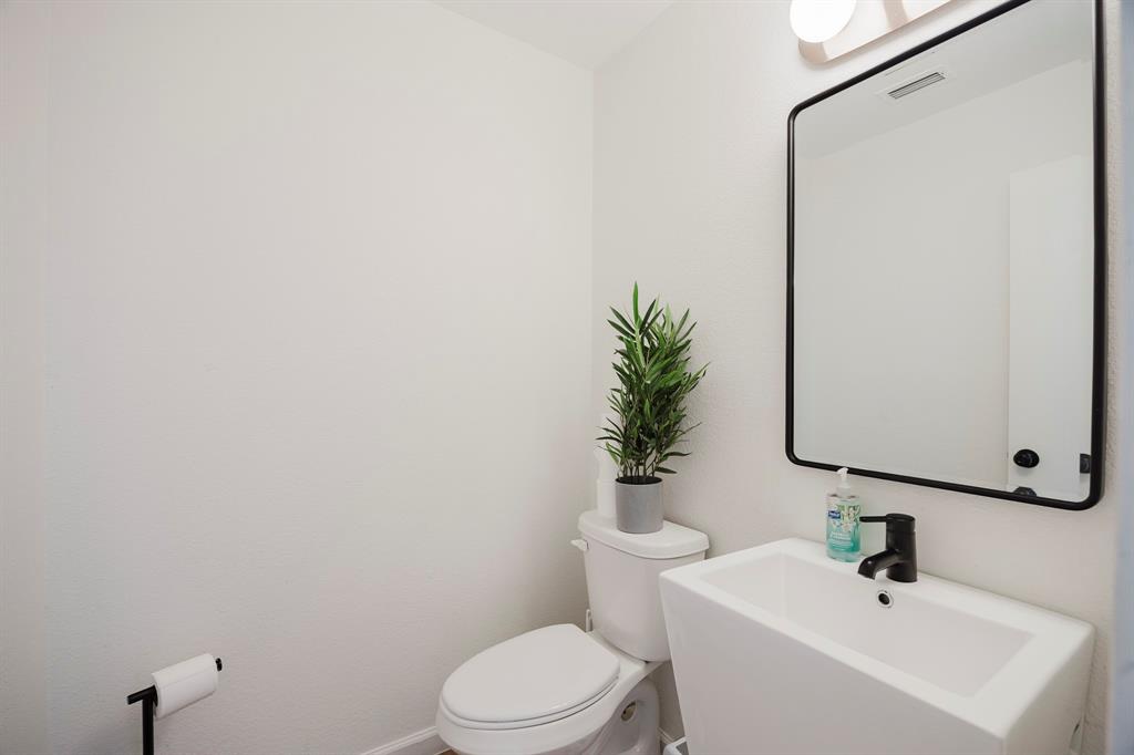 7935 Faithful Trail Dallas, TX 75237 - Photo 20 of 38 a bathroom with a sink a toilet a mirror and shower