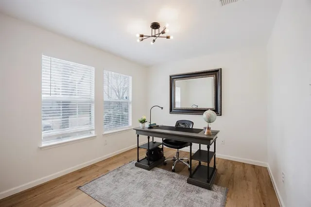 a view of a workspace with furniture and a window