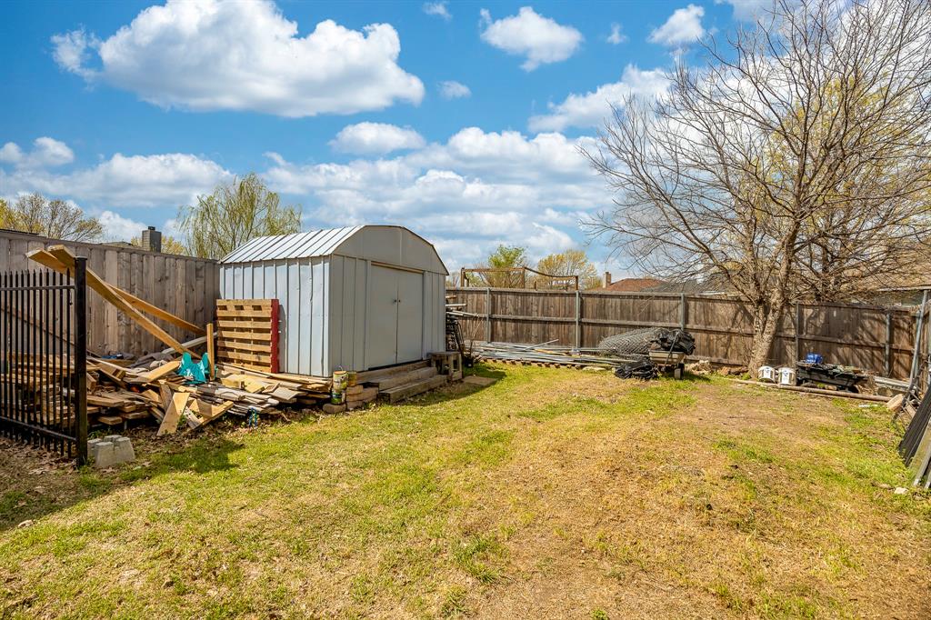 7935 Faithful Trail Dallas, TX 75237 - Photo 35 of 38 Fenced backyard featuring a storage shed