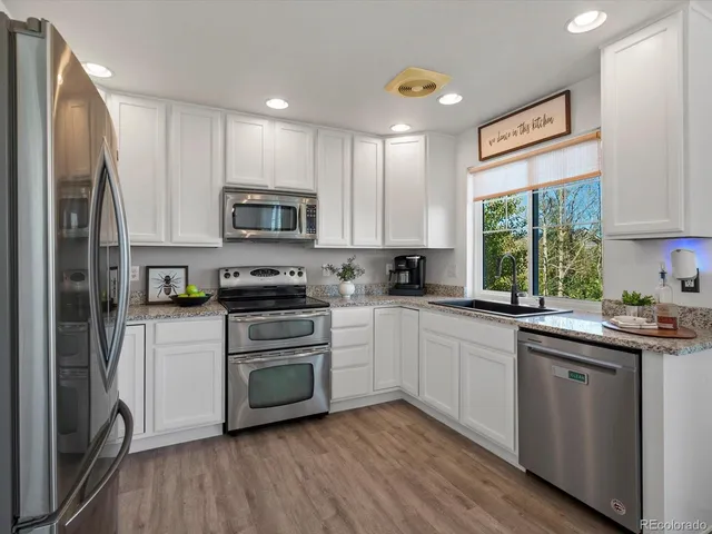 a kitchen with stainless steel appliances granite countertop a stove a sink and a microwave