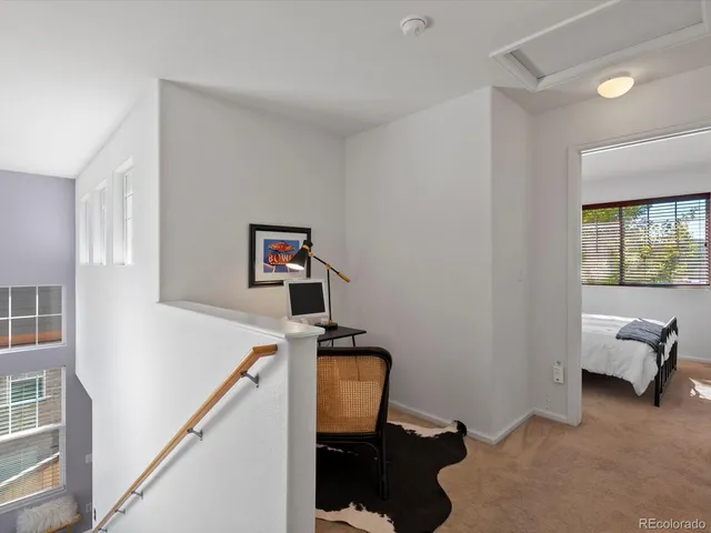 a view of a workspace with furniture and a window