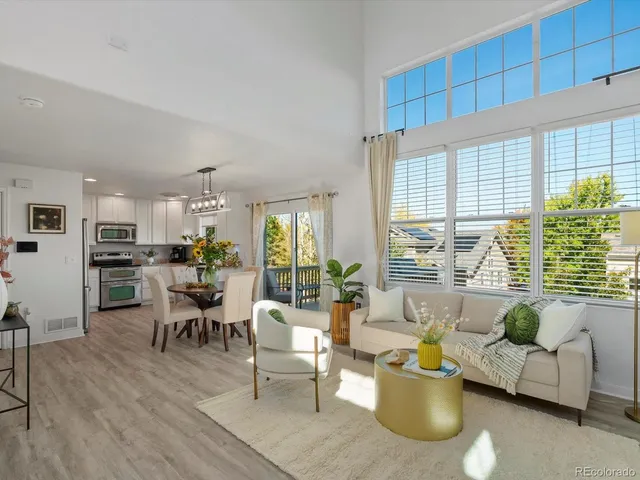 a living room with furniture and floor to ceiling windows