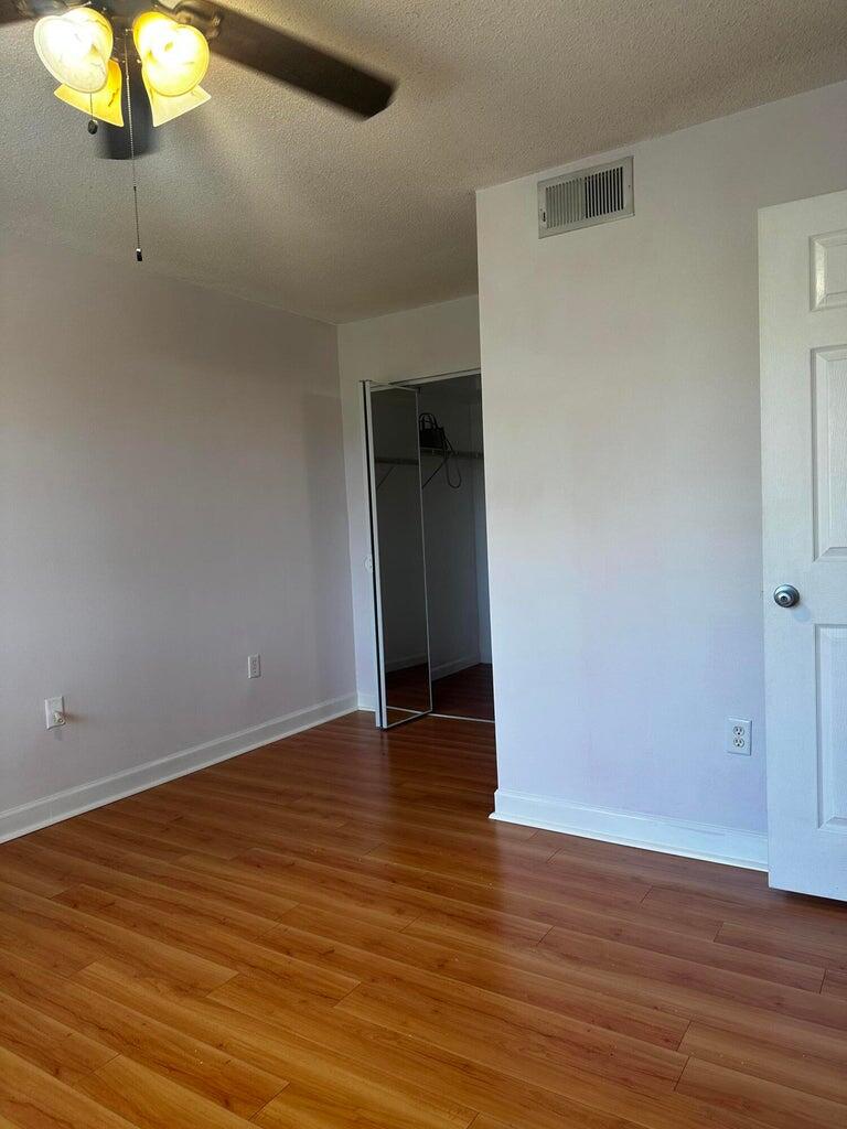 3615 Northwest Adriatic Lane, Unit 204 Jensen Beach, FL 34957 - Photo 12 of 40 a view of an empty room with wooden floor and a window
