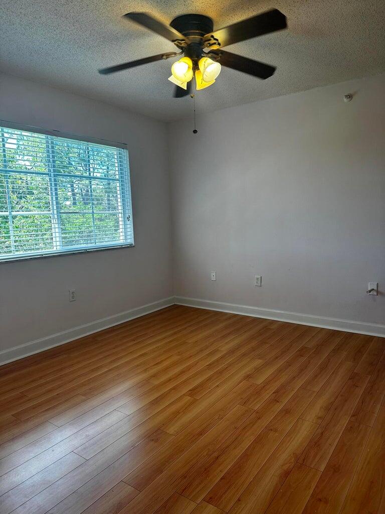 3615 Northwest Adriatic Lane, Unit 204 Jensen Beach, FL 34957 - Photo 15 of 40 a view of an empty room with wooden floor and a window