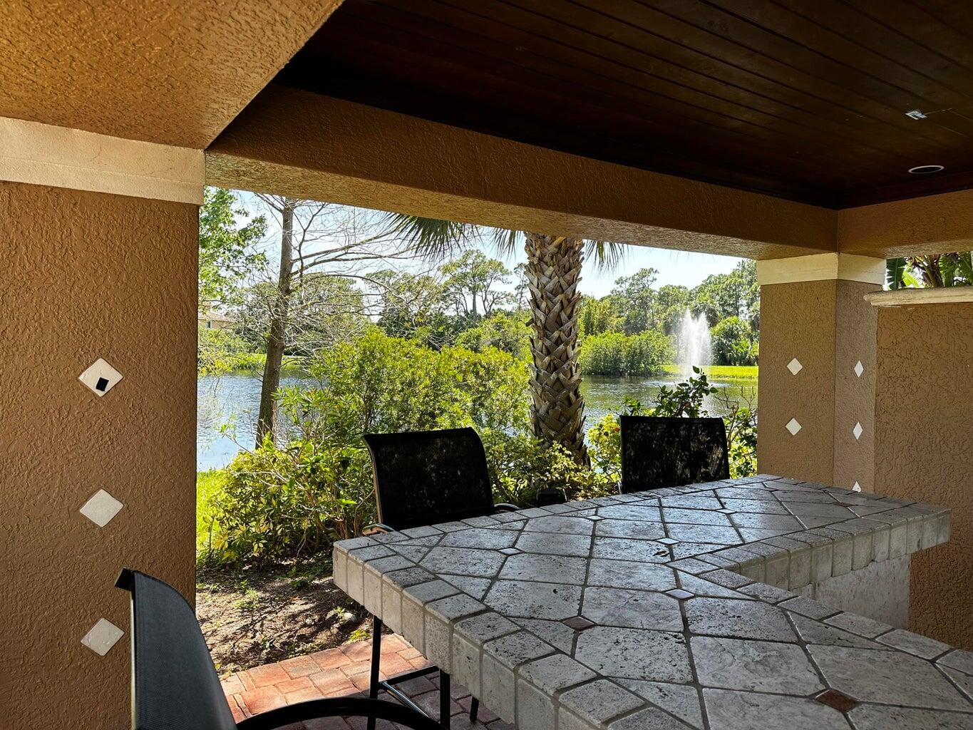 3615 Northwest Adriatic Lane, Unit 204 Jensen Beach, FL 34957 - Photo 29 of 40 a view of a porch with furniture and yard