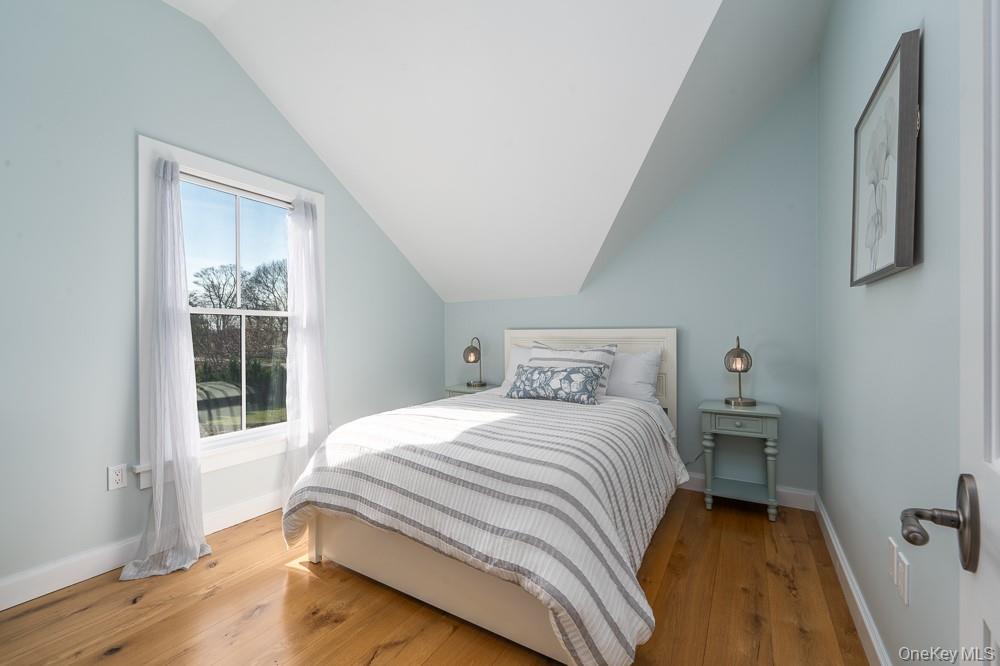 19000 Main Road Mattituck, NY 11952 - Photo 22 of 32 Bedroom featuring vaulted ceiling, baseboards, and hardwood / wood-style floors